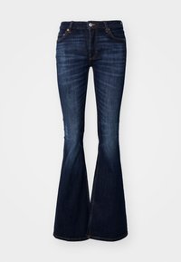 Jeans acampanados de color azul oscuro, fabricados en denim, con una cintura ajustada, diseño de cinco bolsillos y costuras visibles a lo largo de las costuras y los dobladillos.