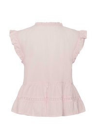 Blouse sans manches rose clair avec bordure à volants sur les manches et l'ourlet, avec une délicate bande en dentelle près du bas.