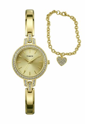 Guld Timex-ur med krystalaccenter og et matchende guldkædearmbånd med en hjerteformet vedhæng med krystaller.