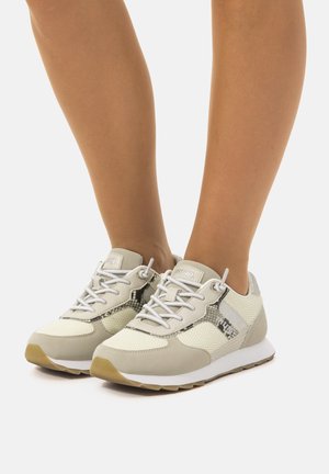 Zapatillas deportivas de color gris claro con parte superior de malla y cuero sintético, que presentan detalles en estampado de serpiente, texturas y cordones blancos.