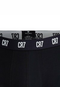Boxer briefs neri in cotone con una ampia fascia in navy che presenta il testo ripetuto "CR7". Include etichetta per la cura e cartellino campione di vendita.