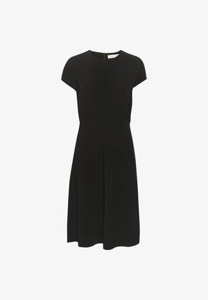 Melnā kleita ar īsām piedurknēm, krokotu vidukļa detaļu, līdz ceļiem garu apakšmalu un diskretu aizmugurējo rāvējslēdzēju. Gluda, viegla auduma.