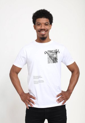 Witte katoenen T-shirt met een zwart-wit illustratie, handgeschreven tekst en gedrukte tekst aan de onderkant. Korte mouwen en ronde hals.