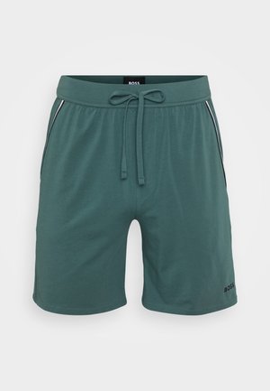 Shorts verts en tissu doux, dotés d'une ceinture élastique avec cordon de serrage, de poches latérales et d'un accent de logo noir sur l'ourlet.