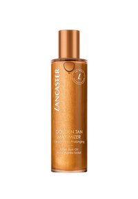 Gouden tan olie in een doorzichtige fles. Kenmerkt zich door een metallic gouden dop, een zachte textuur en gouden glitters. Etiket bevat productdetails in het wit.