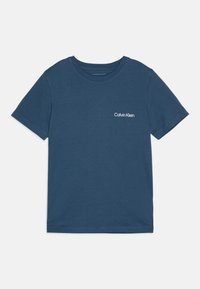 Tamsiai mėlynas džinsinis marškinėliai su trumpomis rankovėmis, apvali iškirptė ir balta "Calvin Klein" logo kairėje krūtinės pusėje. Lygaus paviršiaus, kasdieniškas dizainas.