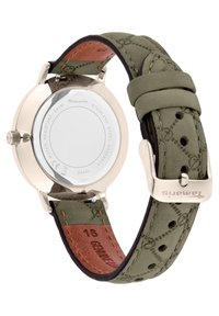 Quarzuhren mit einem Gehäuse aus Edelstahl, grünem Wildlederarmband mit Nähten und einer braunen Lederunterseite, gesichert mit einer silbernen Schnalle.