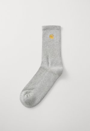 Meia cinza canelada com biqueira redonda e um emblema amarelo, apresentando um design casual adequado para o uso diário.