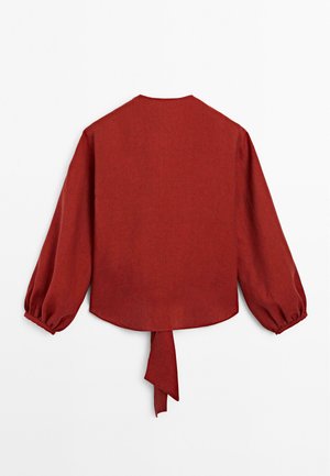 Rote Leinenbluse mit Puffärmeln, rundem Halsausschnitt und einer Rückenschnürung. Verfügt über einen leicht geschwungenen Saum und eine glatte Textur.
