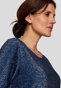 Marineblaues Sweatshirt mit metallischen Glitzern, runder Ausschnitt und strukturiertem Stoff. Verfügt über eine lockere Passform und lange Ärmel.
