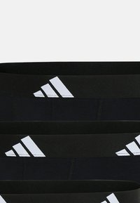 Svarta sportleggings med en bred midja och en vit tre-strips logotypdesign. Tillverkade av elastiskt tyg för komfort.