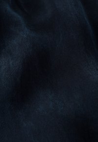 Tmavě modrá tkanina s jemným leskem, zobrazující strukturovaný povrch a měkký spad, vhodná pro různé použití v módě nebo čalounění.