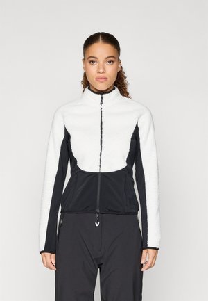 Fleece jacket featuring white textured upper and black stretchy lower sections, with a high collar and front zip closure. Adjustable hem.
