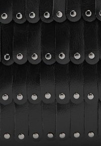 Musta nahkamateriaali, jossa päällekkäisiä suikaleita ja hopeanvärisiä metallinauloja. Pinnassa on tekstuuri, joka luo kerroksellisen muotoilun.