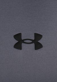 Mørk grå stof har et struktureret mønster med et sort Under Armour-logo, der er tydeligt placeret i midten.