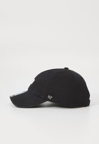 Sort bomuldske cap med en buet skygge, der har et hvidt logo foran og en subtil broderet detalje på siden.
