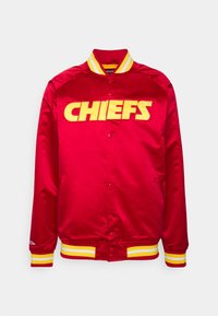 Jacket di raso rosso con scritta gialla "CHIEFS". Presenta un colletto a coste e polsini a strisce gialle. Chiusura con bottoni a scatto davanti.