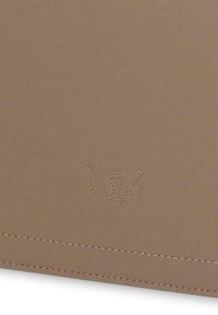 Portefeuille en cuir brun texturé avec un logo papillon embossé discret, des coutures renforcées et une finition extérieure lisse.