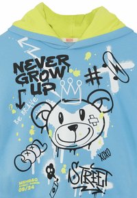 Sudadera azul con una capucha interior de un vibrante verde lima. Presenta un gráfico de un oso, texto en estilo graffiti y salpicaduras de colores en negro y amarillo.