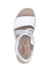 Sandalia blanca con correas cruzadas, plantilla suave y suela flexible. Presenta un upper de cuero liso y un diseño ligero y acolchado.
