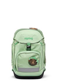 Zaino verde con tessuto testurizzato, tasca frontale con zip e design di un orso in una toppa circolare. Presenta una striscia riflettente e un manico superiore.