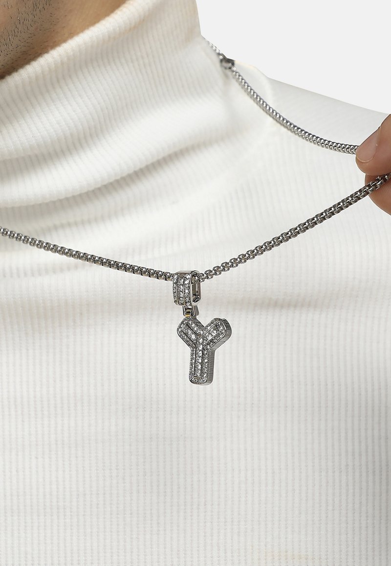Sølv kæde med en cubic zirconia-beklædt "Y" vedhæng, med en glat tekstur og geometrisk design.