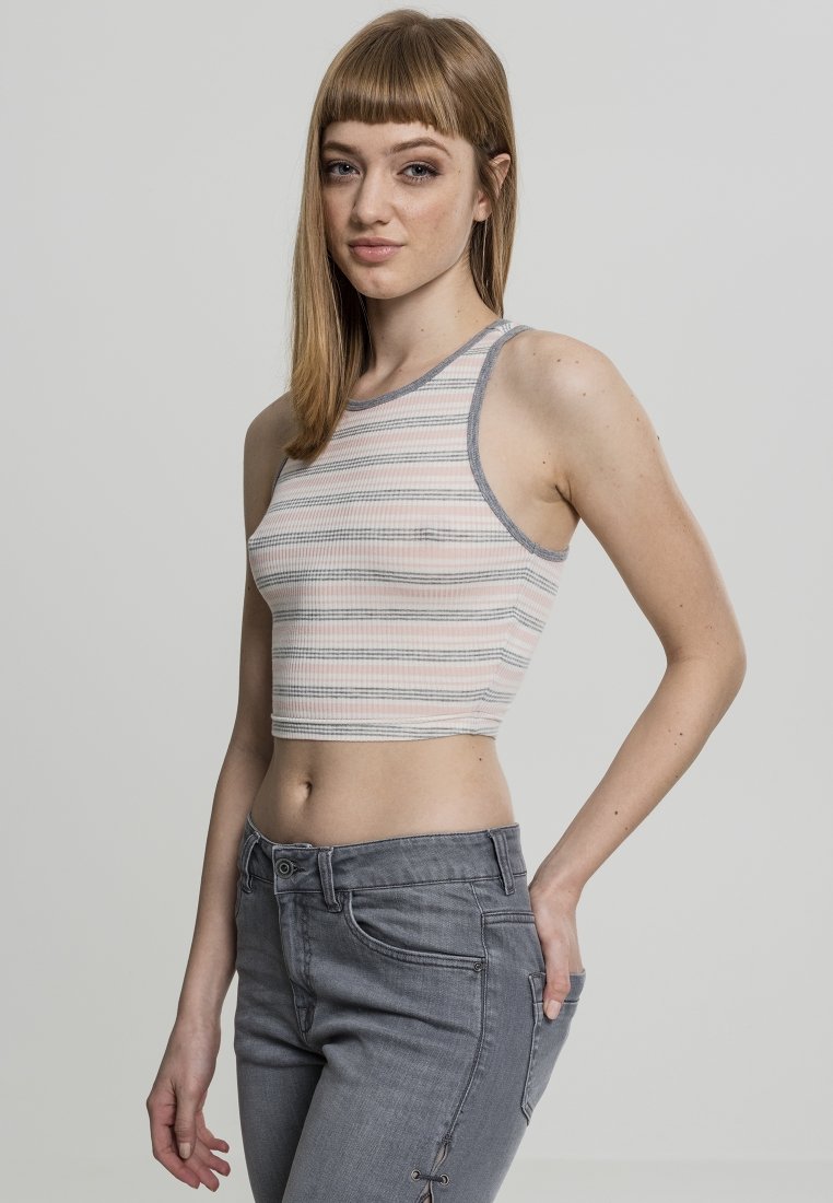 Top corto a rayas en rosa claro, gris y blanco. Textura acanalada, sin mangas, con ribetes grises. Combinado con jeans gris ajustados que presentan costuras decorativas.