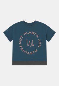 T-shirt de manga curta verde-água com um gráfico circular em rosa com o texto "NOT PLASTIK" e "FANTASTIK", apresentando uma bainha preta em contraste.