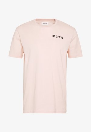 T-shirt rose clair à manches courtes avec des caractères japonais imprimés en noir sur la poitrine gauche et un col rond.