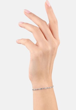 Pulsera de plata con pequeñas piedras multicolores. Diseño delgado y delicado. Usada en una mano parcialmente visible contra un fondo simple.