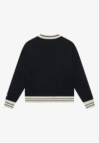 Hanorac negru cu guler și manșete cu dungi, având dungi crem la marginea de jos și la deschiderile mânecilor. Material moale, texturat.