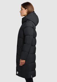 Čierny prešívaný kabát s kapucňou, s prešívaným dizajnom, dlhými rukávmi a bočnými vreckami na zips. Hladká, lesklá textúra látky.