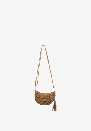 Sac bandoulière tressé marron avec une sangle tressée et un pompon suspendu sur fond blanc.