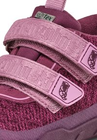 Roze schoenen met een bovenwerk van textiel. Voorzien van twee verstelbare klittenbandsluitingen, textuurmateriaal en een logoaccent op de band.