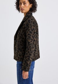Leopardenmuster-Jacke aus weichem Stoff mit taillierter Passform, mit Reverskragen, zwei Knöpfen und Seitentaschen.
