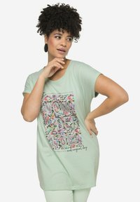 Camisa de manga corta verde menta con un gráfico floral y la palabra "MARAVILLOSO" en letras en negrita. Tejido suave con un corte relajado.