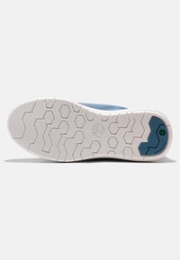 Suola di sneaker in tessuto blu con gomma bianca, caratterizzata da un motivo di battistrada esagonale e accenti verdi. Design durevole, adatto a diversi terreni.
