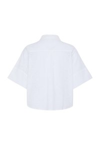 Blouse blanche à manches courtes avec broderie florale ajourée, coupe ample et carrée, et col classique vue de dos.