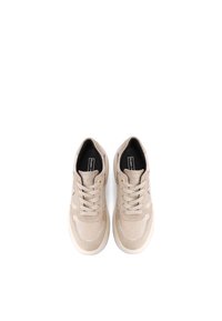 Sneakers beige in suede con suole in gomma liscia, punta rotonda, lacci piatti e dettagli di cucitura discreti. L'interno presenta un rivestimento nero a contrasto.