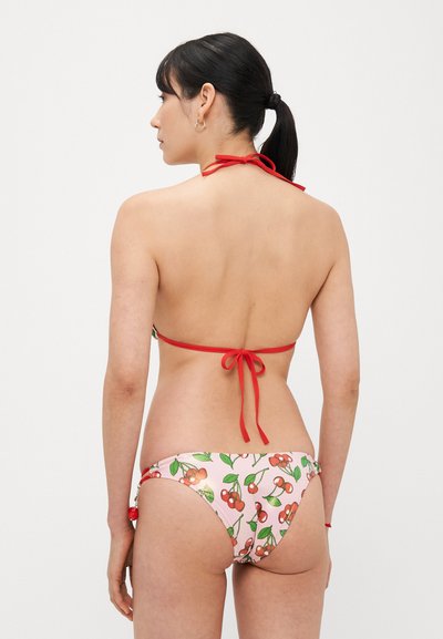 Bikini z czerwonym wiązaniem na szyi. Dół wykonany z różowej tkaniny ozdobionej wzorem wiśni, z zielonymi liśćmi i czerwonymi akcentami.