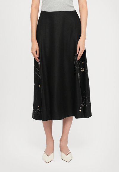 Falda midi negra con patrones celestiales bordados en dorado y blanco, con una textura suave y forma acampanada.