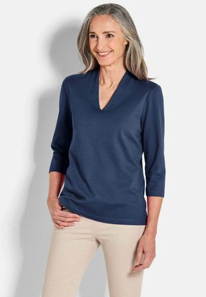 Marineblaues V-Ausschnitt-Oberteil mit Dreiviertelärmel, aus weichem, elastischem Stoff, mit glatter Textur und minimalistischem Design.