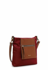 Red nylon shoulder bag with a brown faux leather pocket, silver zipper, and adjustable strap. Features a minimalist design and contrasting textures.