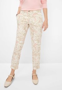 Pantalons de couleur claire avec des motifs floraux roses et des lignes beiges, dotés de poches latérales, d'une fermeture à bouton et d'une coupe droite.