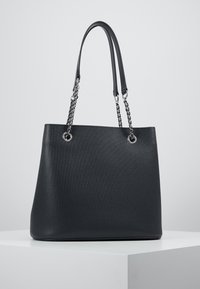 Sac fourre-tout texturé noir avec poignées duales en chaîne et en cuir, avec quincaillerie en métal argenté et un design à ouverture supérieure.