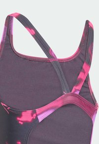 Paars en roze gestreept badpak met smalle bandjes; gladde textuur en een kruisachterontwerp. Heeft contrasterende kleuren en stikdetails.