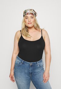 Zwarte tanktop met dunne bandjes, gecombineerd met lichtblauwe high-waisted jeans. Een kleurrijk geprint zijden sjaaltje complementeert de outfit.
