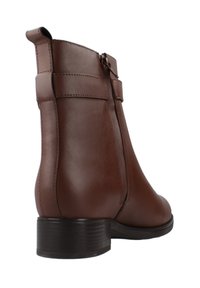 Stivaletto in pelle marrone con texture liscia, zip laterale, due cinturini orizzontali e tacco basso e scanalato.