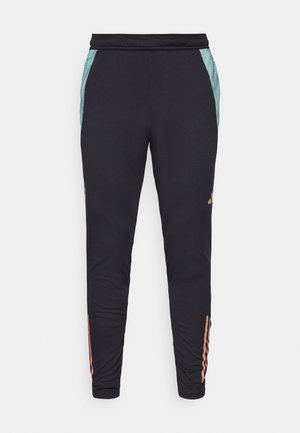 Pantalones deportivos negros con un diseño ajustado, que presentan paneles laterales en color teal y rayas coral cerca de los puños. Hechos de una tela suave y elástica.