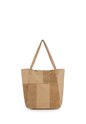 Beige taske med patchworkdesign, der indeholder glatte og ruskindspanele og dobbelte skulderstropper.